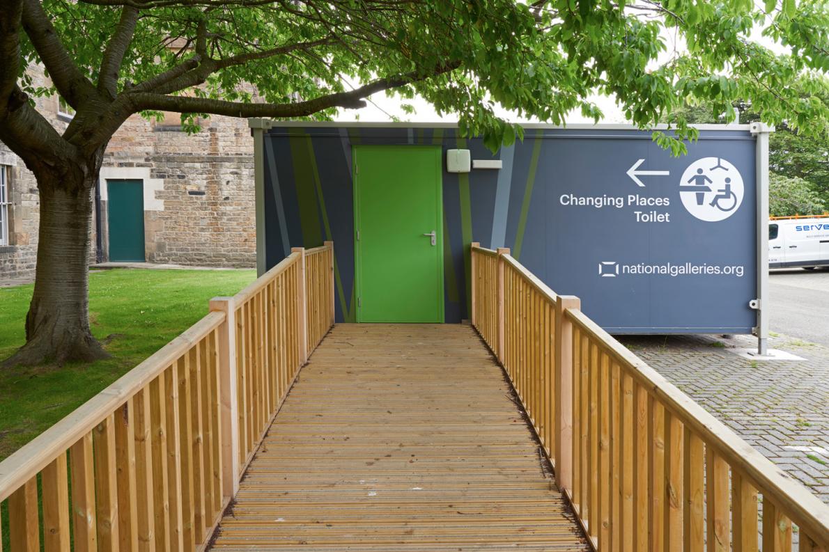 A wood ramp leading to the Changing Places Toilet in the car park behind Modern One
